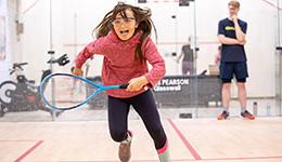 A girl running on a squash court